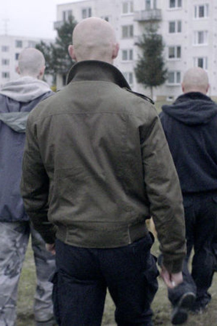 Eine Gruppe von Männern geht in Richtung einer Wohnsiedlung.