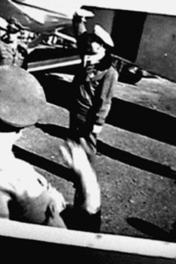 Eine Schwarzweißaufnahme von mehreren Personen in Uniformen und Mützen.