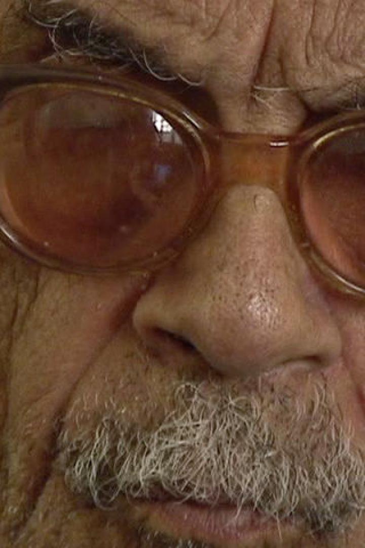 Nahaufnahme eines älteren Mannes mit Brille und grauem Bart.