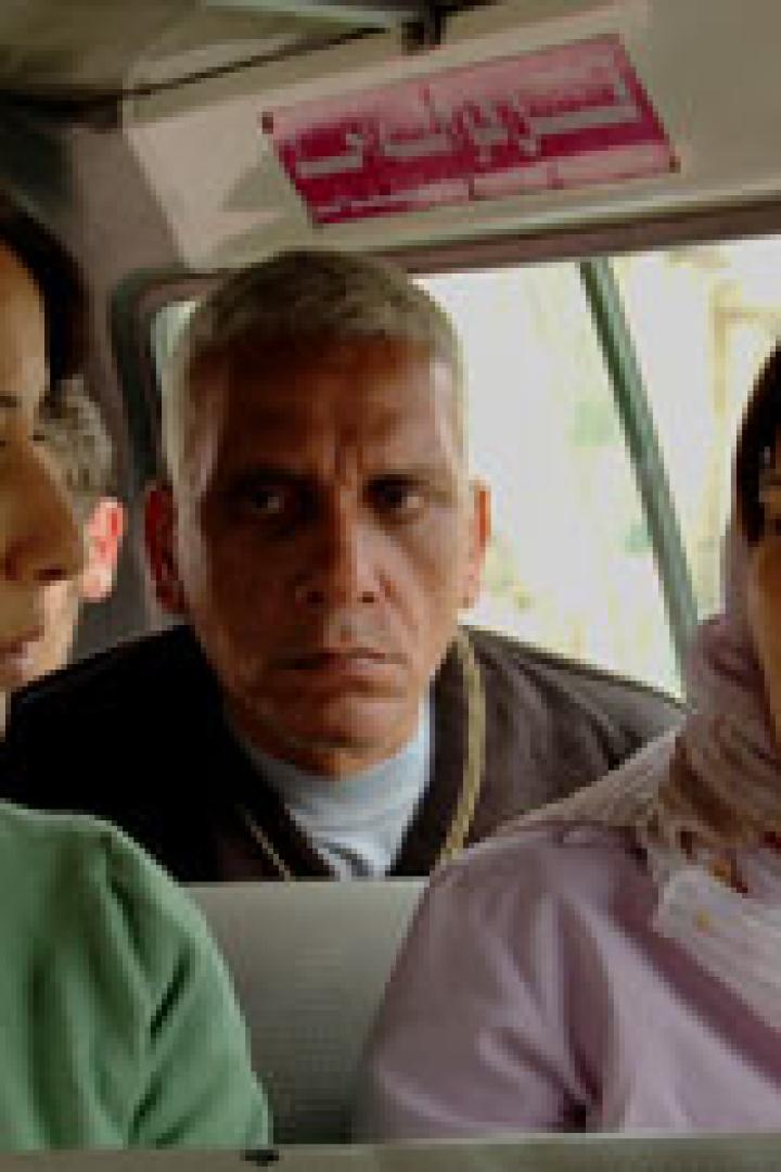 Drei Personen sitzen in einem Fahrzeug, zwei Frauen und ein Mann.