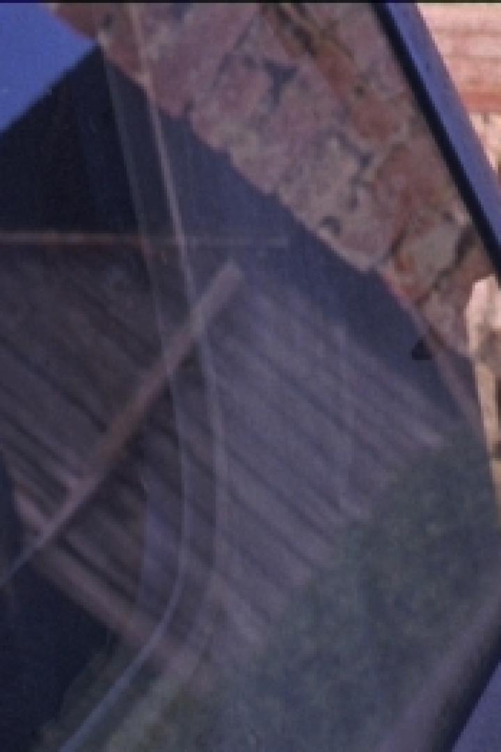 Die Spiegelung eines Gebäudes in einer Autoscheibe.