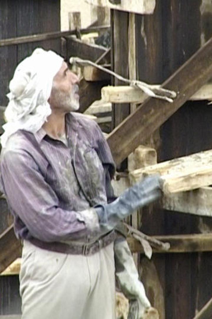 Ein Bauarbeiter mit Turban arbeitet an einer Holzkonstruktion.