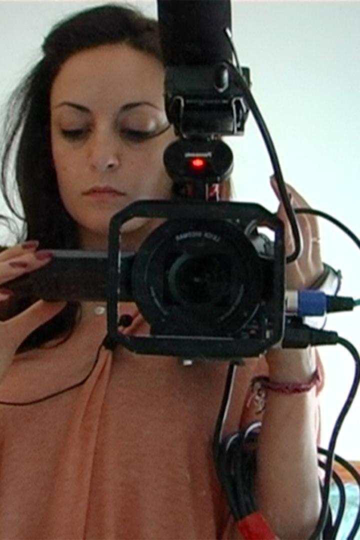 Eine Frau filmt sich selbst mit einer professionellen Videokamera.