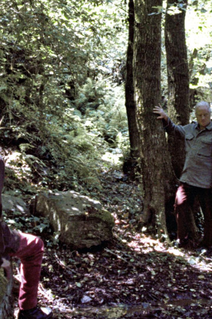 Zwei Männer ruhen sich in einem Waldgebiet aus.