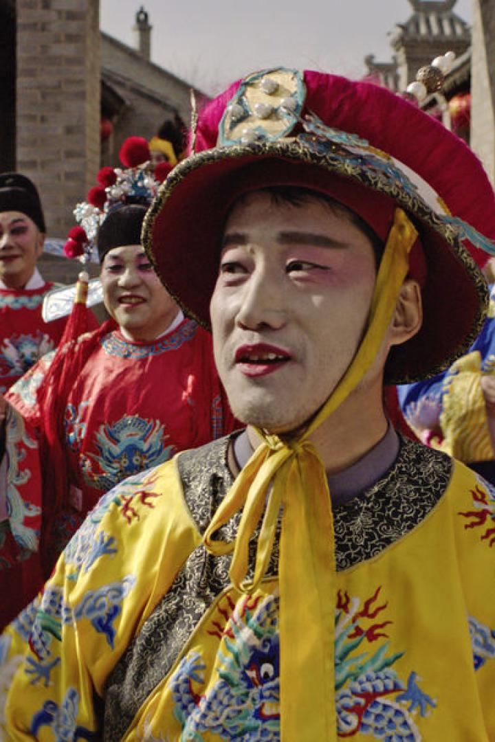 Eine Gruppe von Menschen in traditionellen chinesischen Opernkostümen und Make-up.