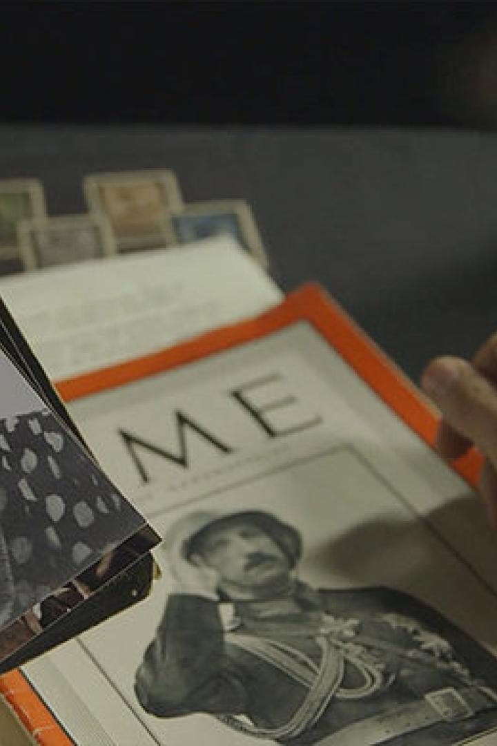 Eine Person betrachtet alte Fotos und eine Zeitschrift mit einem Porträt.