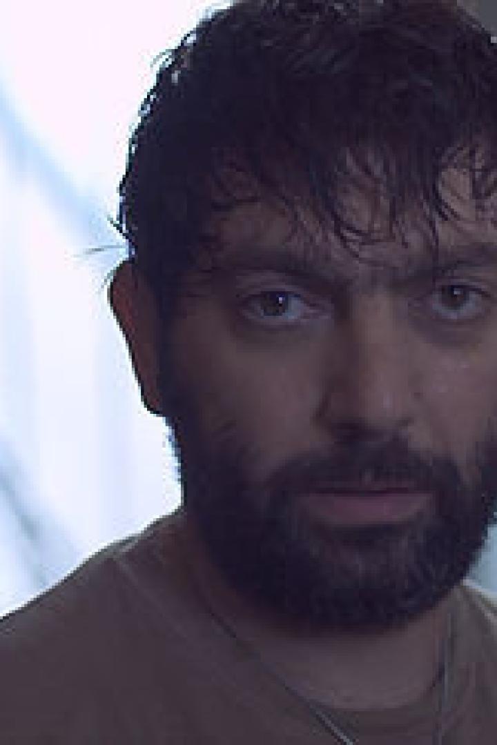 Ein Mann mit Bart und dunklen Haaren blickt in die Kamera.