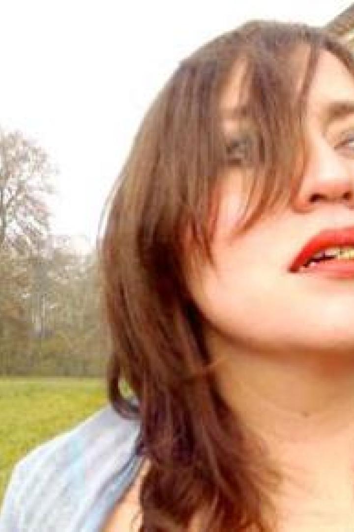 Eine Frau mit roten Lippenstift hat eine Made im Mund.