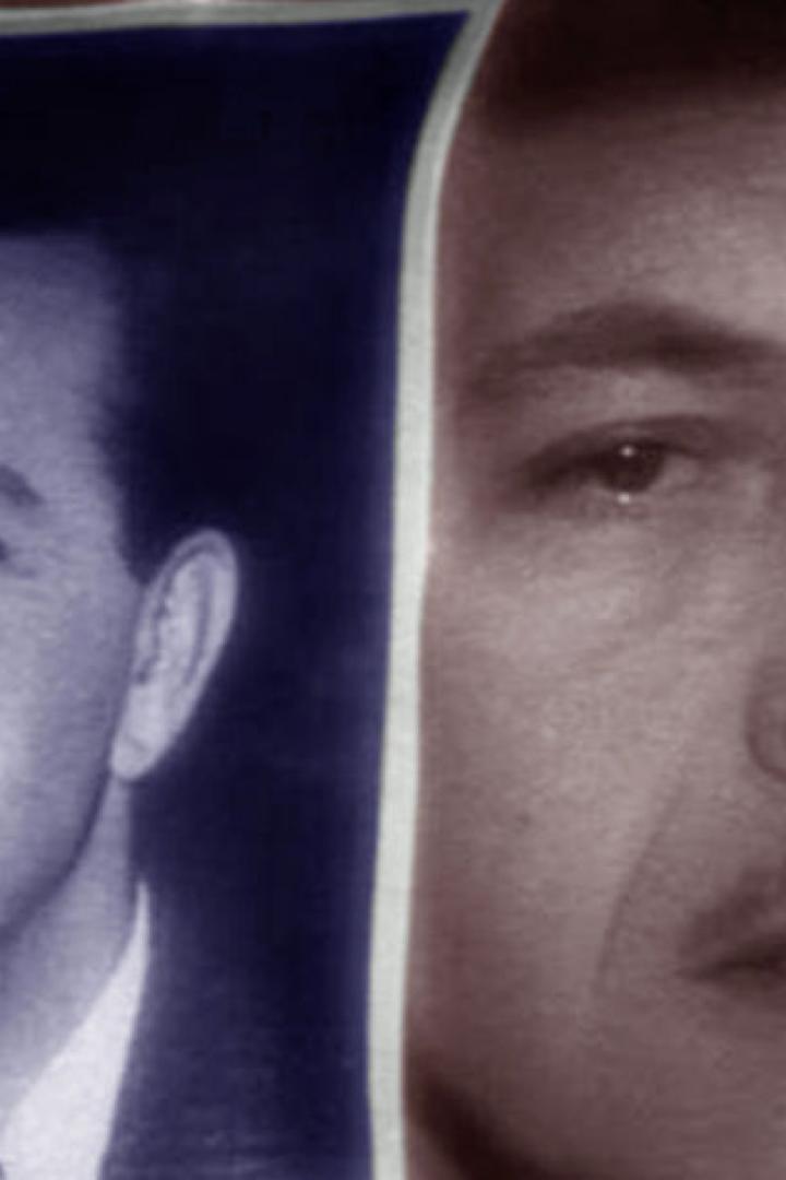 Ein Mann betrachtet ein Schwarzweißfoto eines anderen Mannes.