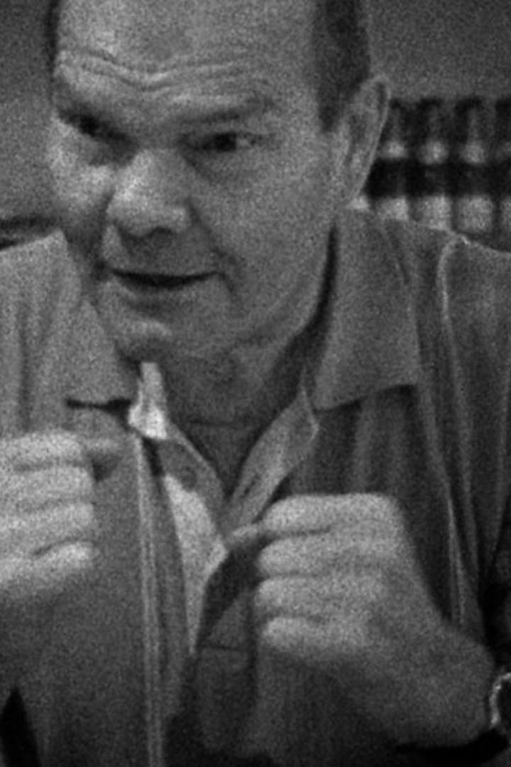 Ein Mann in Schwarzweißaufnahme schließt seine Jacke.