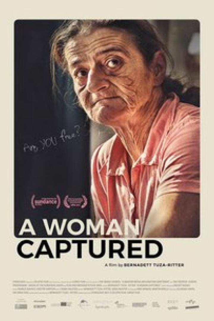 Das Filmplakat für „A Woman Captured“ zeigt eine ältere Frau in einem rosa Hemd.
