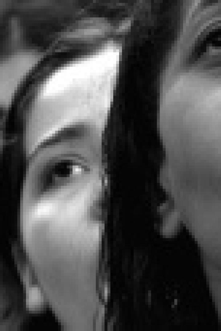 Eine Frau schreit mit geöffnetem Mund, während andere Frauen im Hintergrund zu sehen sind.