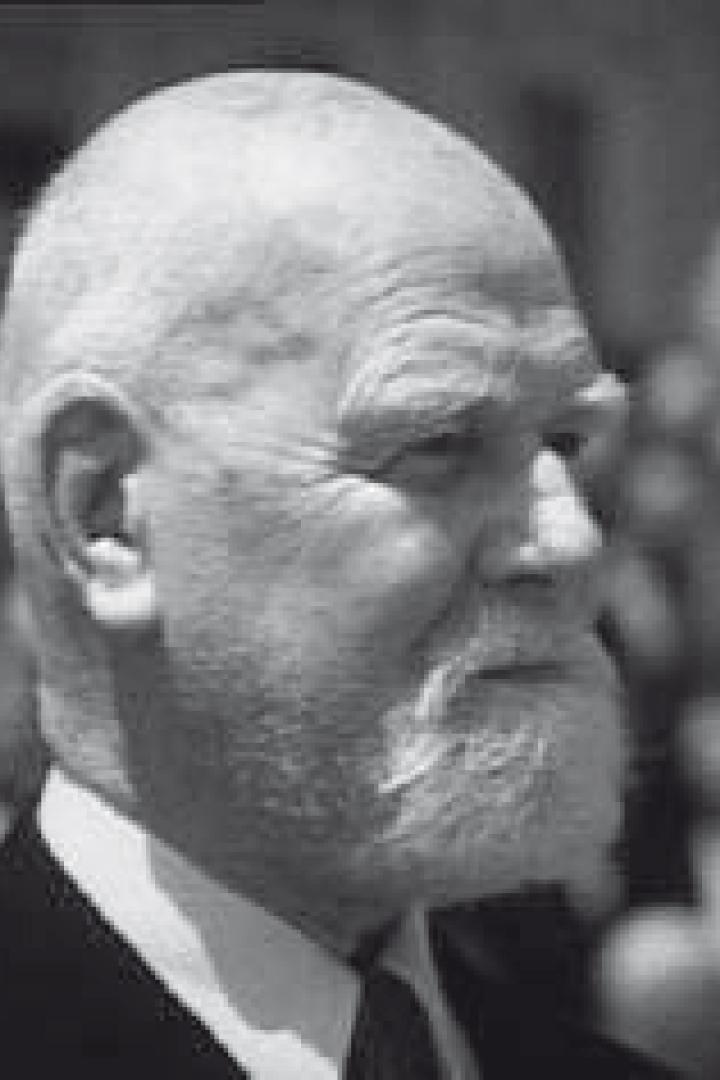 Ein älterer Mann mit Bart und Anzug blickt nach rechts.