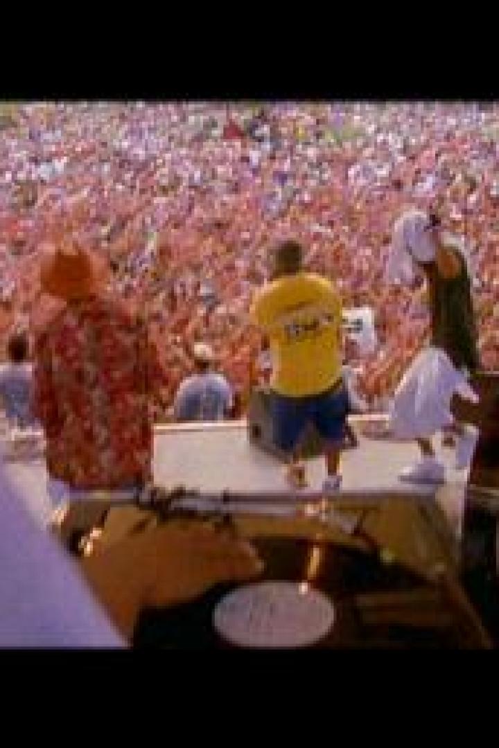 Eine Band tritt vor einer riesigen Menschenmenge im Freien auf.