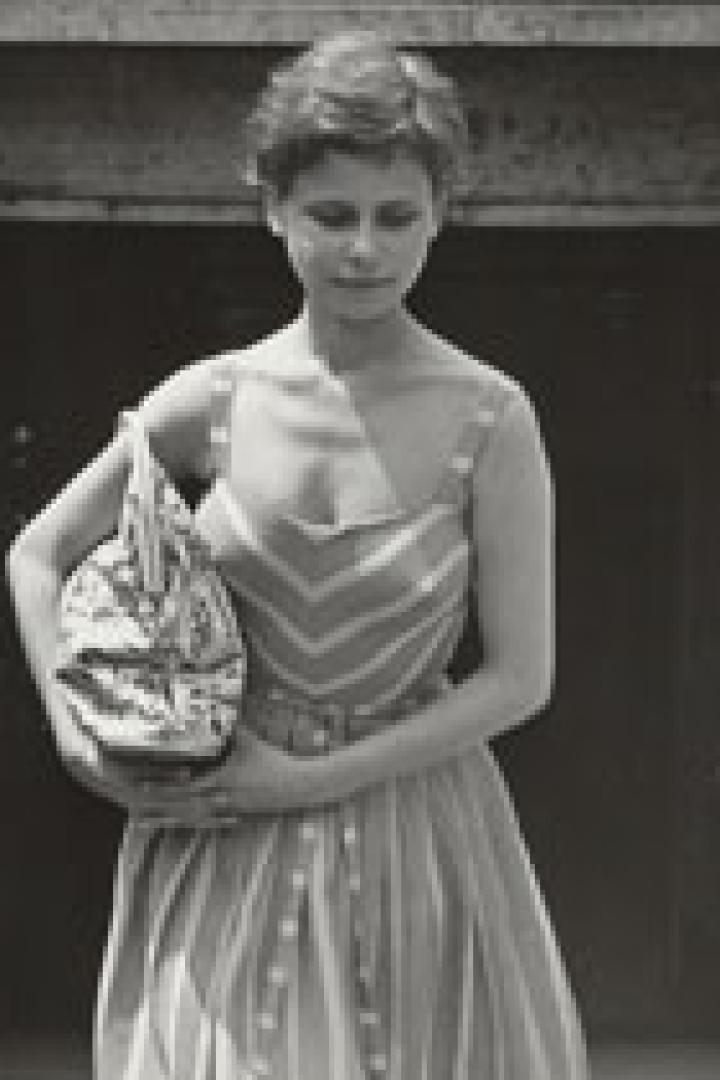 Eine junge Frau in einem gestreiften Kleid verlässt eine U-Bahn-Station.