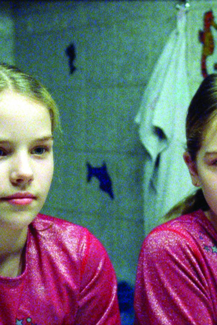 Ein junges Mädchen steht vor einem Spiegel im Badezimmer.