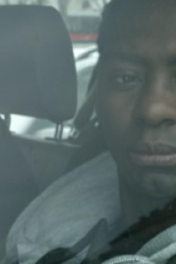 Ein Mann sitzt in einem Auto, möglicherweise in Polizeigewahrsam.