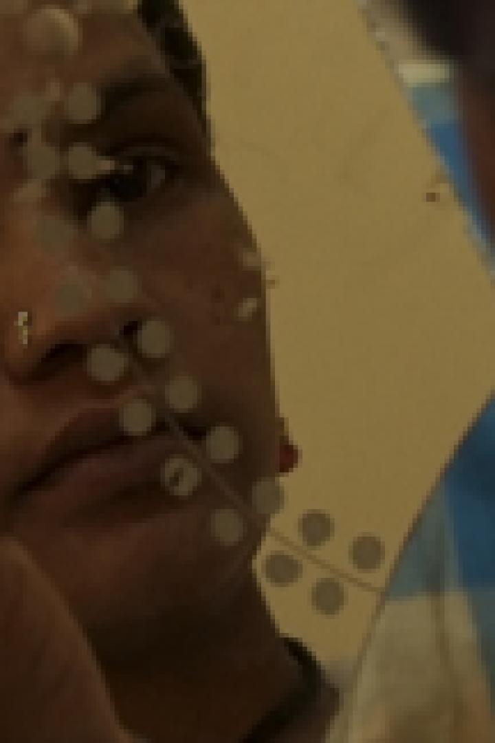 Eine Person mit Nasenring betrachtet sich in einem Spiegel.