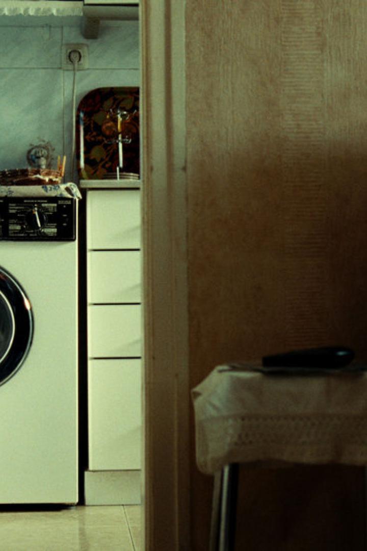 Blick durch eine Tür auf eine Waschmaschine und einen Sessel.