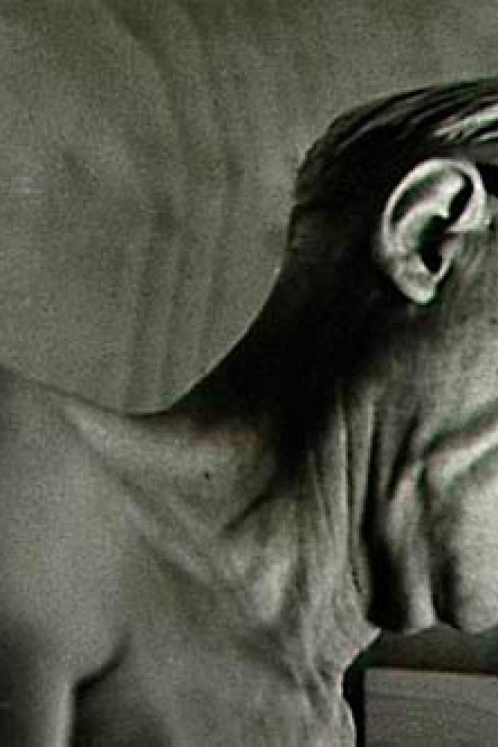 Ein älterer Mann mit Brille blickt nach unten.