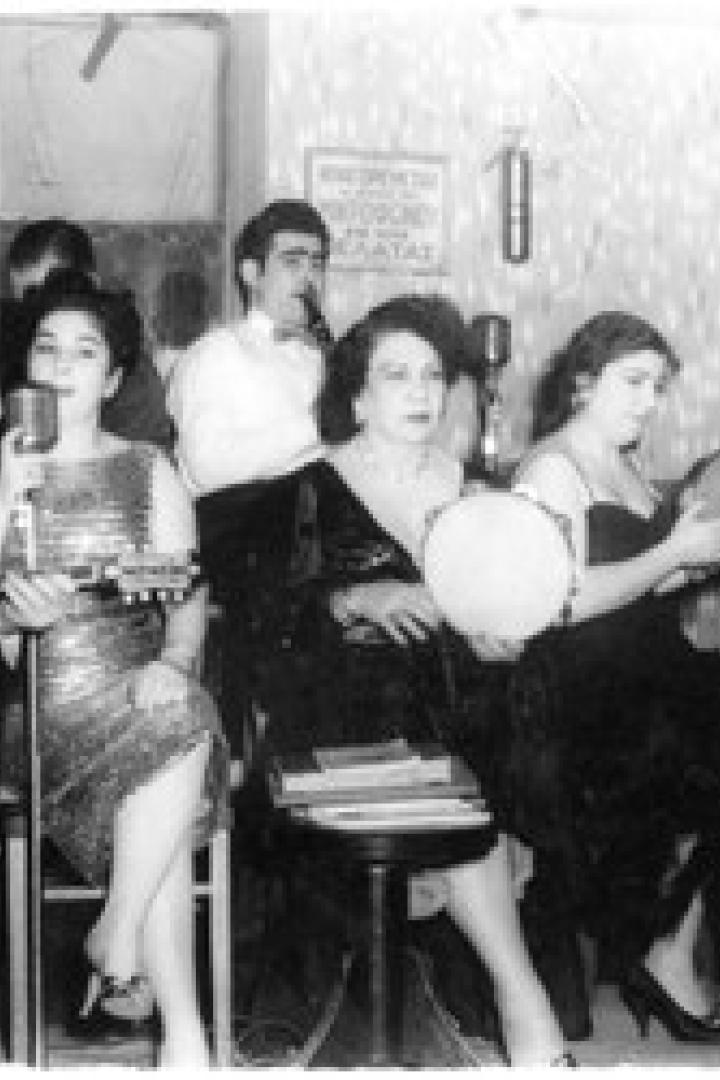 Eine Musikgruppe spielt in einem kleinen Raum mit Mikrofonen und traditionellen Instrumenten.