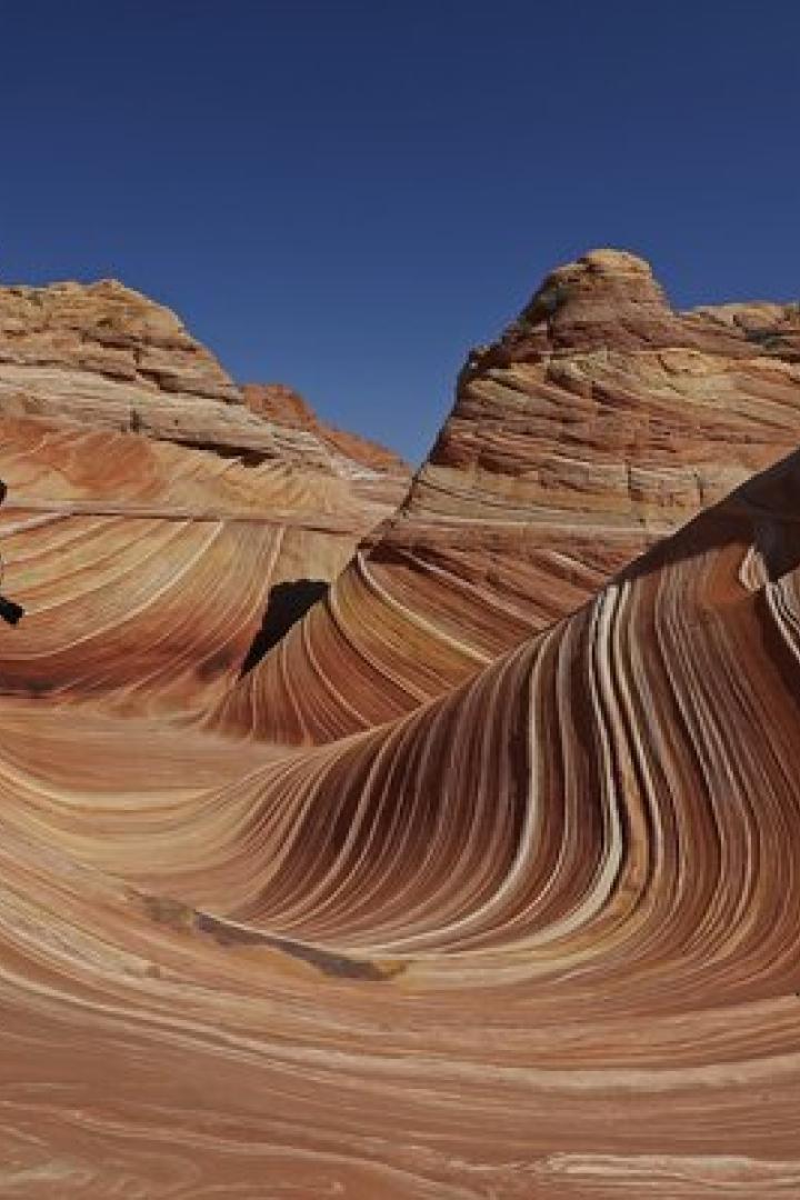 Ein Mann steht barfuß in der wellenförmigen Felsformation „The Wave“ in Arizona.
