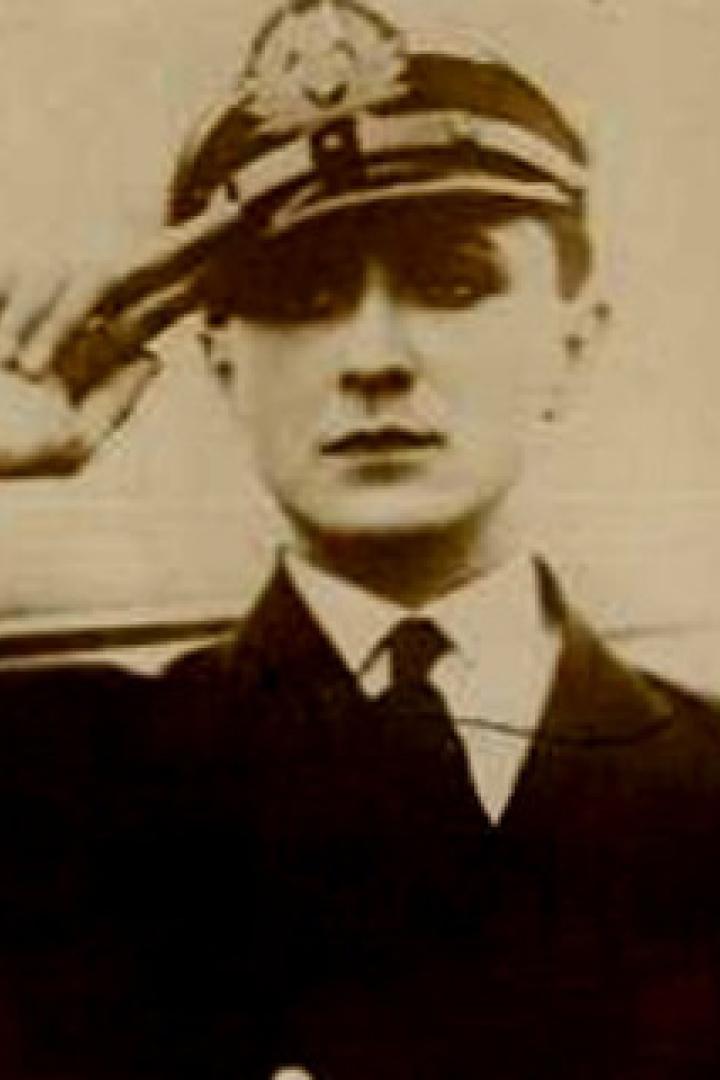 Ein junger Mann in Marineuniform salutiert.