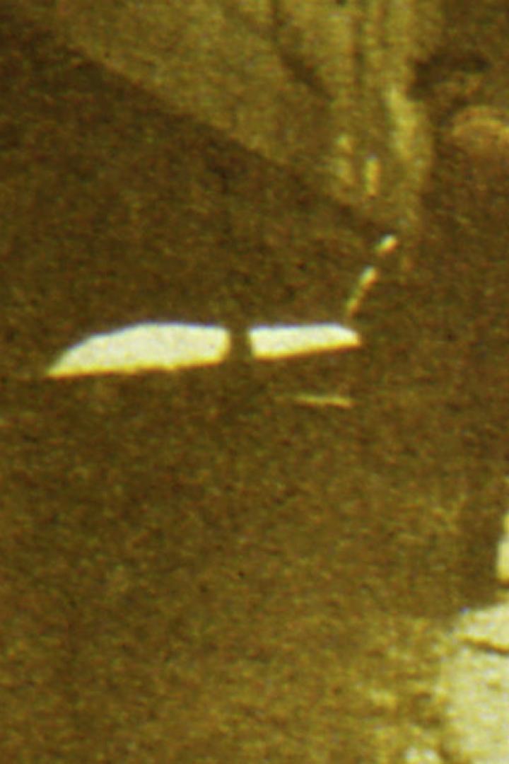 Eine Person geht eine Straße entlang, die von Gebäuden gesäumt ist.