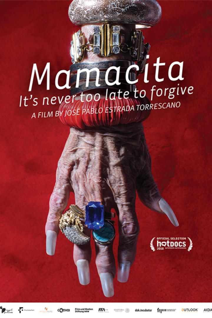 Das Filmplakat von „Mamacita“ zeigt eine Hand mit auffälligem Schmuck vor rotem Hintergrund.