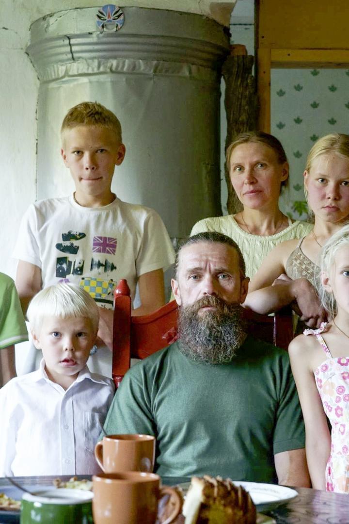 Eine Familie posiert in einem ländlichen Haus für ein Gruppenfoto.