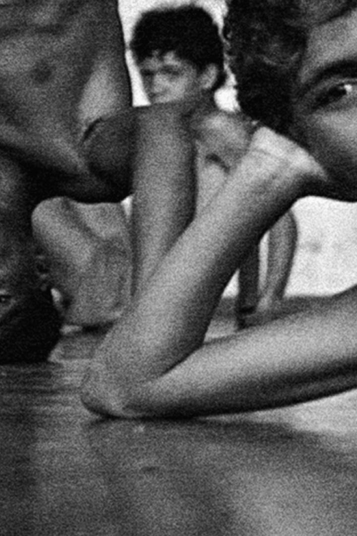 Mehrere junge Männer üben Yoga in einem dunklen Raum.
