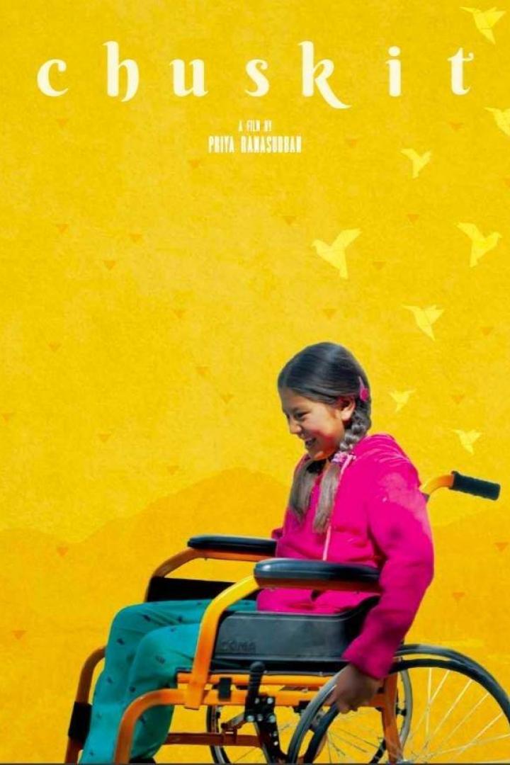 Das Filmplakat für „Chuskit“ zeigt ein Mädchen im Rollstuhl vor einem gelben Hintergrund.