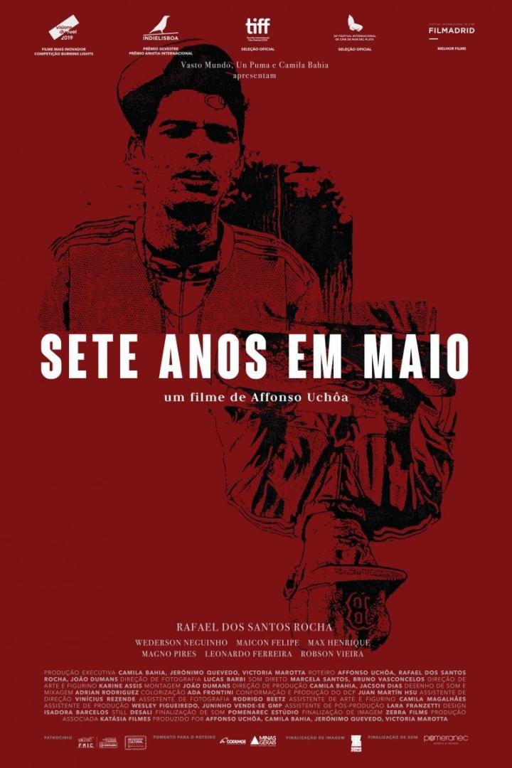 Das Filmplakat für „Sete Anos em Maio“ zeigt ein Porträt eines jungen Mannes in Rot- und Schwarztönen.