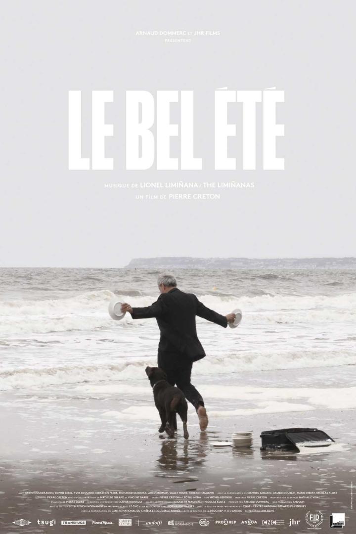 Ein Mann mit Hund läuft am Strand entlang, im Hintergrund das Filmplakat „Le Bel Été“.