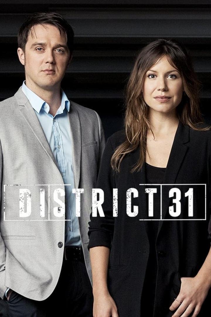 Ein Mann und eine Frau vor dem Logo der Fernsehserie „District 31“.