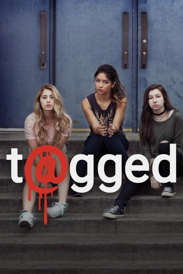 Drei junge Frauen sitzen auf einer Treppe vor einer blauen Tür, im Hintergrund der Schriftzug „Tagged“.