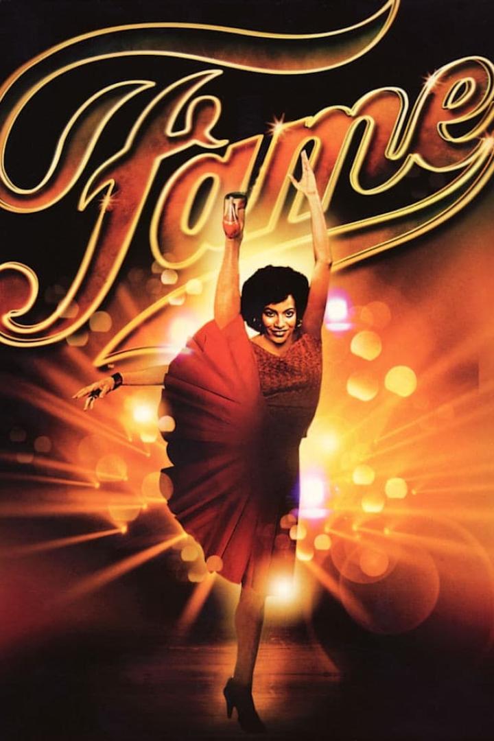 Eine Tänzerin in einem roten Kleid posiert vor dem Schriftzug „Fame“.