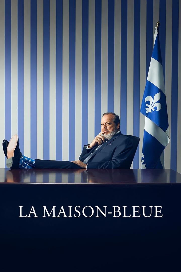 Ein Mann sitzt mit Füßen auf dem Tisch vor der Flagge von Québec; Titel „La Maison-Bleue“.