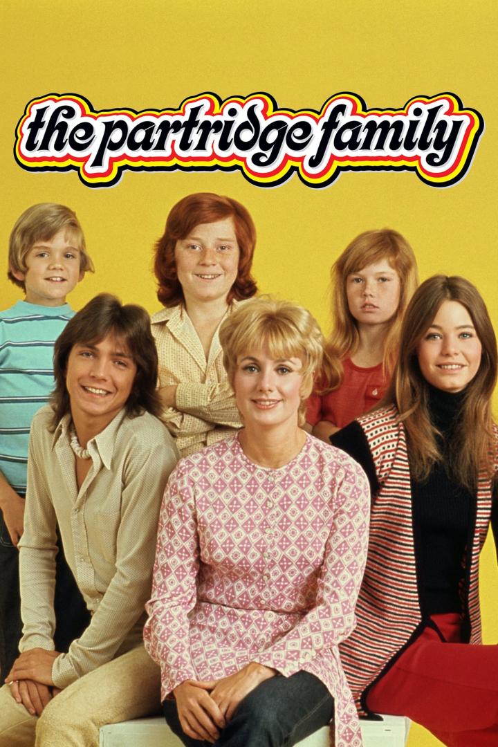 Das Ensemble der Fernsehserie „The Partridge Family“ posiert vor gelbem Hintergrund.