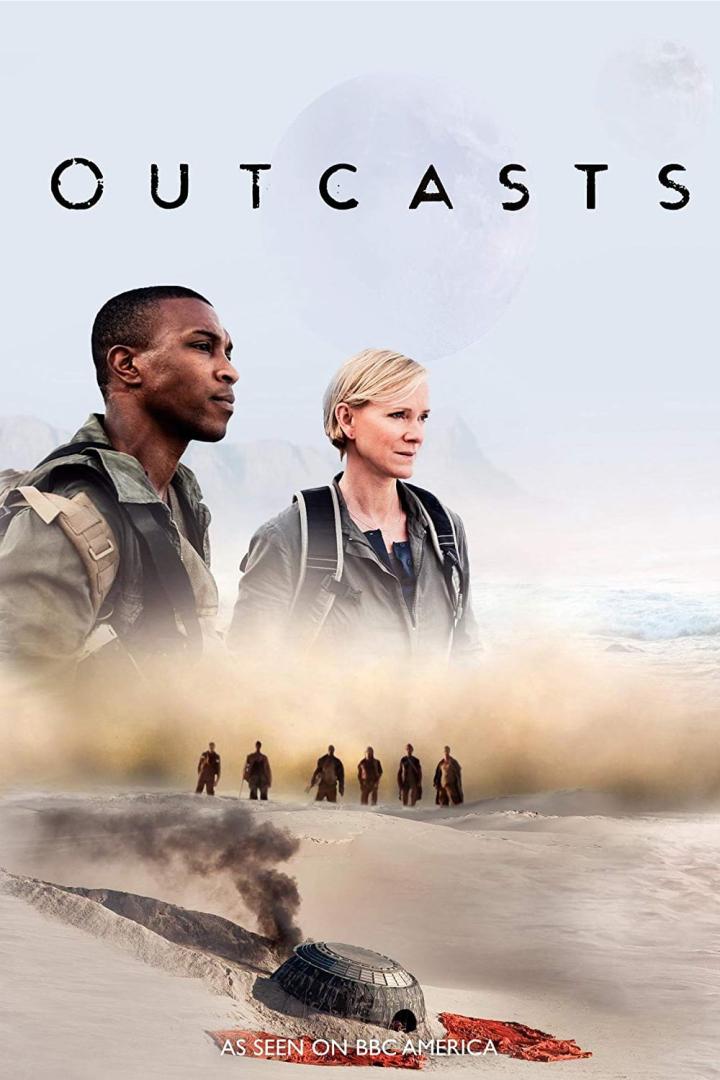 Das Filmplakat für „Outcasts“ zeigt zwei Personen vor einer Wüstenlandschaft mit einem abgestürzten Raumschiff.