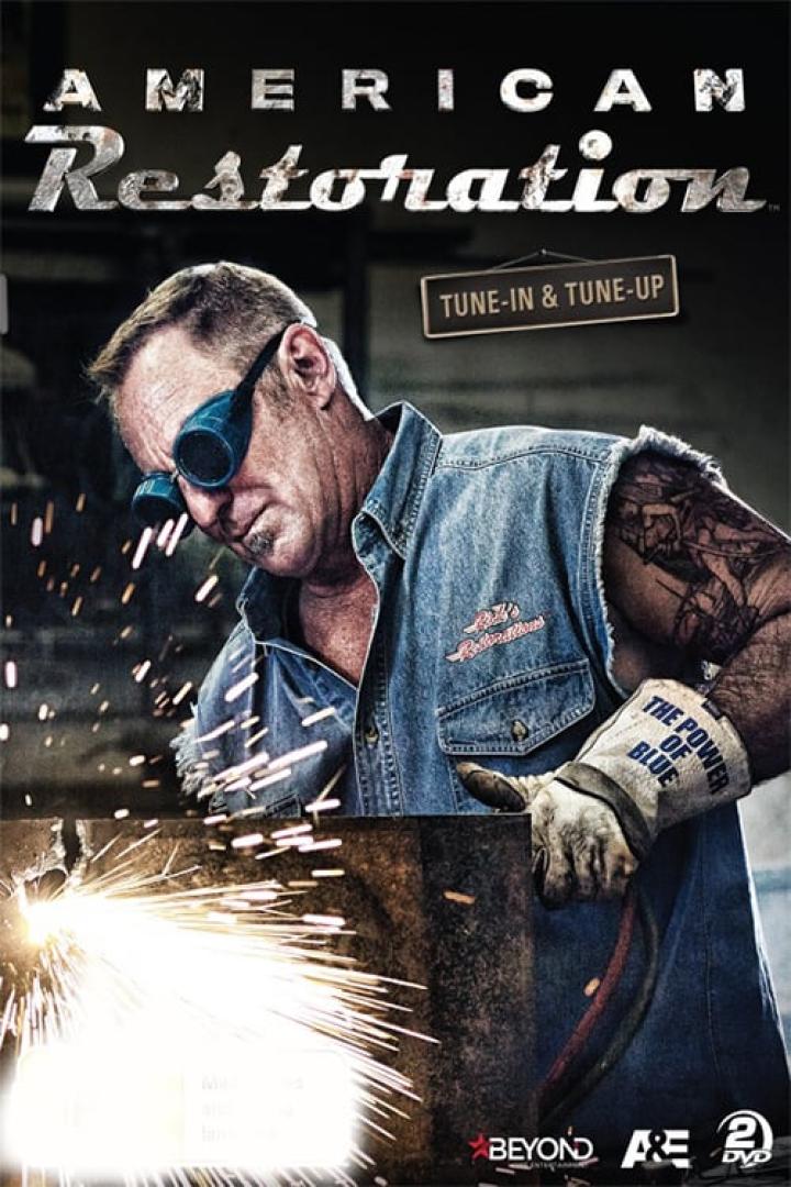 Ein Mann mit Schweißerbrille schweißt Metall in der Werkstatt „American Restoration“.
