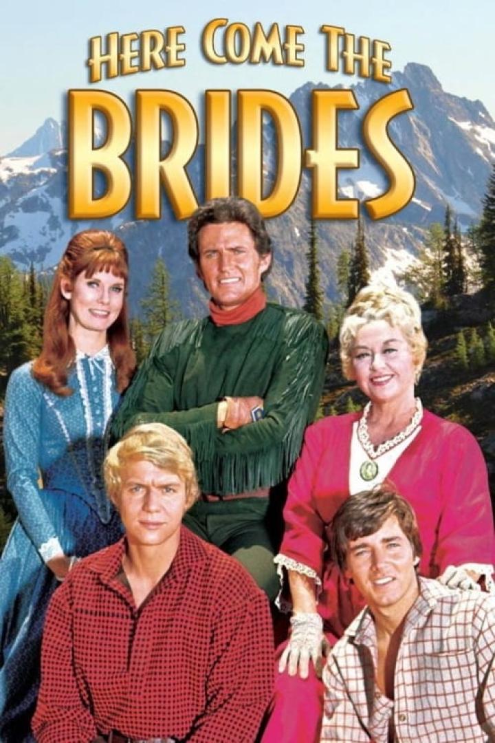 Das Filmplakat für „Here Come the Brides“ zeigt die Hauptdarsteller vor einer Bergkulisse.