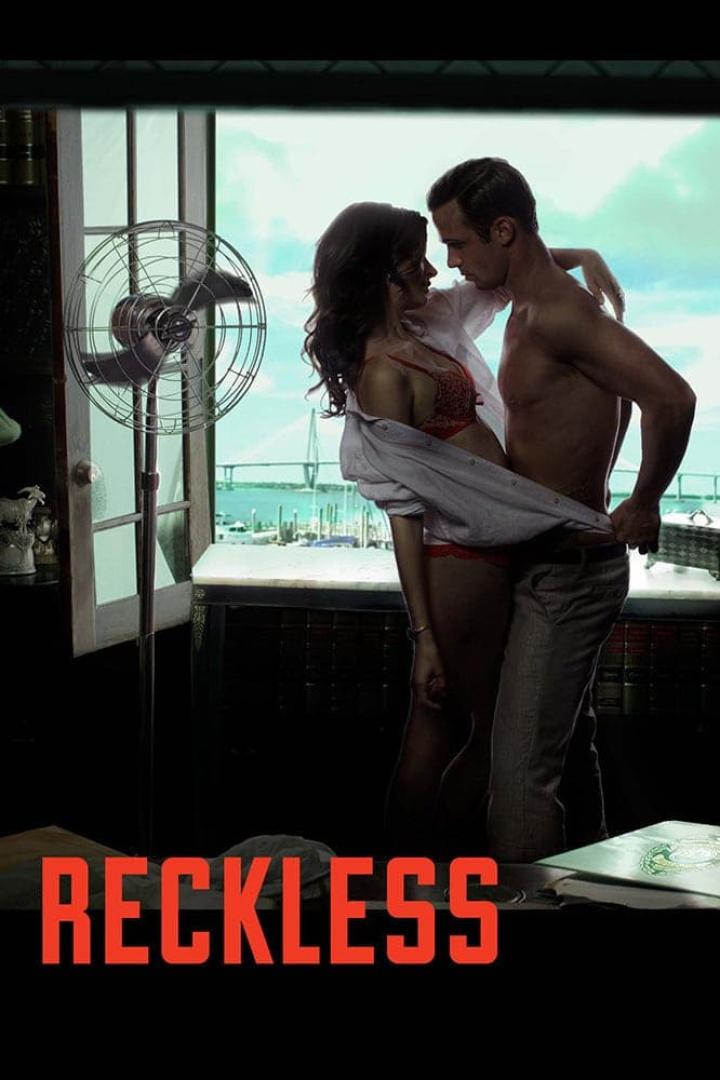 Ein Paar umarmt sich vor einem Fenster mit Blick auf das Meer, im Vordergrund der Titel „Reckless“.