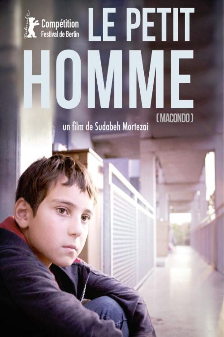 Das Filmplakat für „Le Petit Homme“ zeigt einen Jungen vor einem Gebäude.