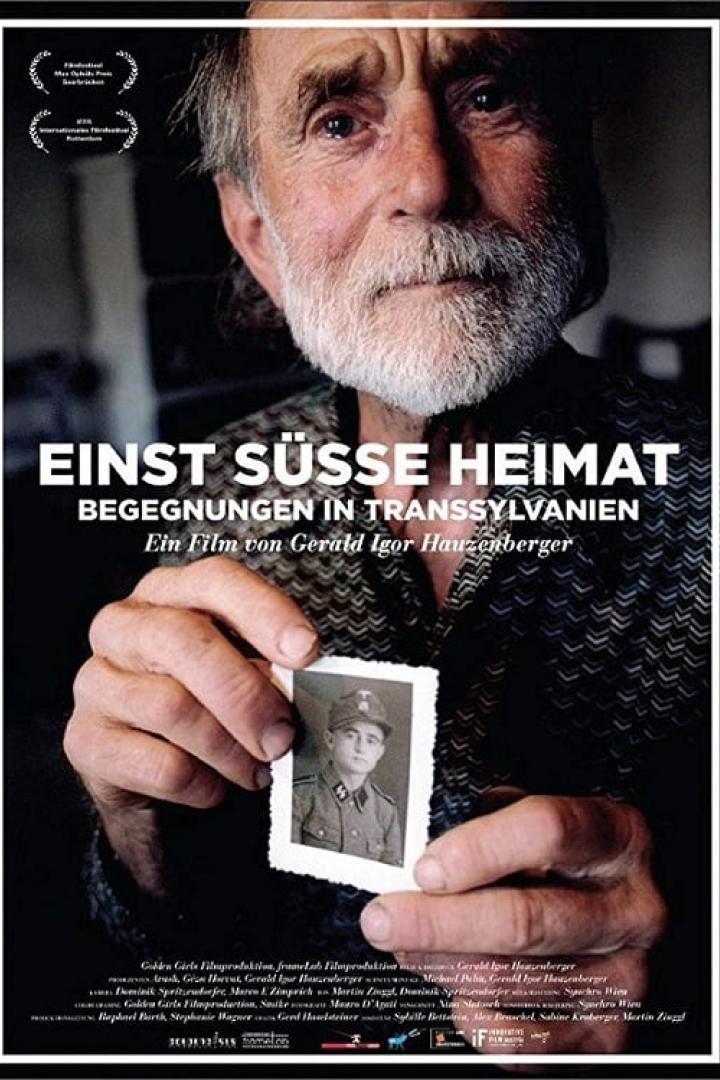 Ein älterer Mann hält ein Foto eines jungen Mannes in Uniform, vermutlich eine Szene aus dem Film „Einst süße Heimat“.