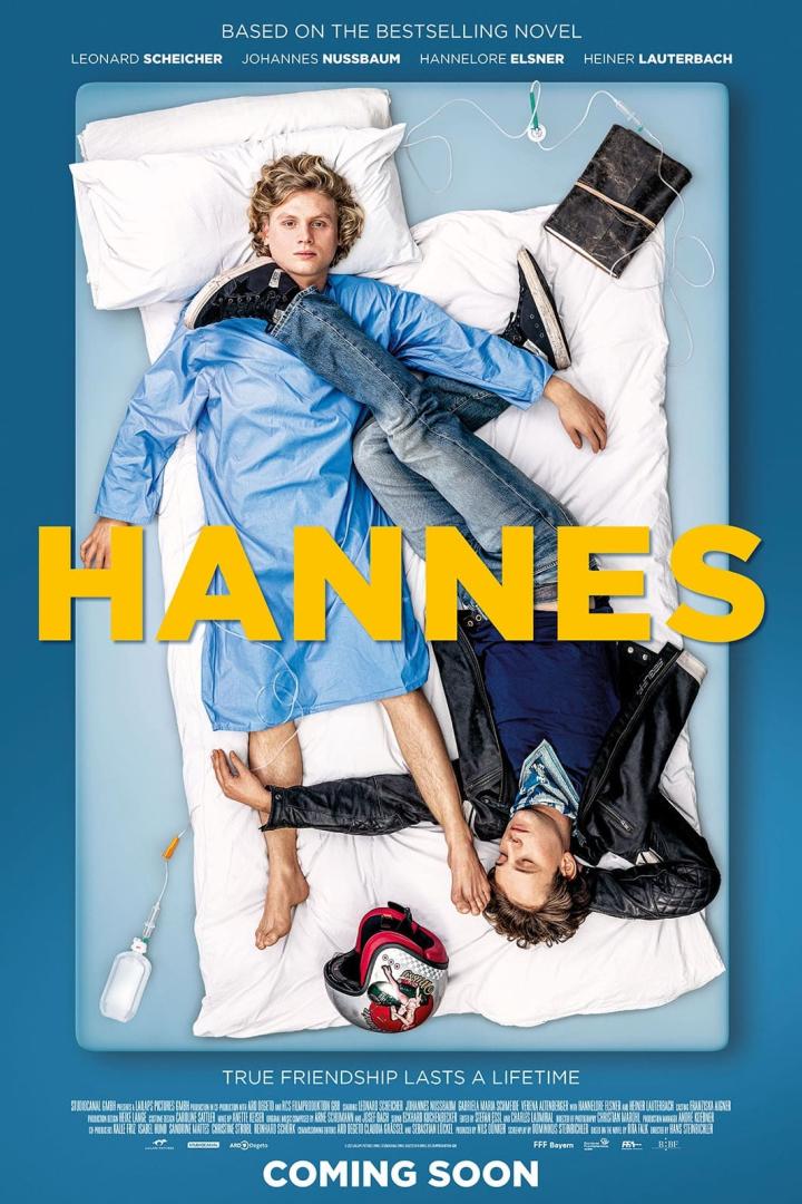 Das Filmplakat zu „Hannes“ zeigt zwei junge Männer, einer im Krankenhaushemd, auf einem Bett liegend.