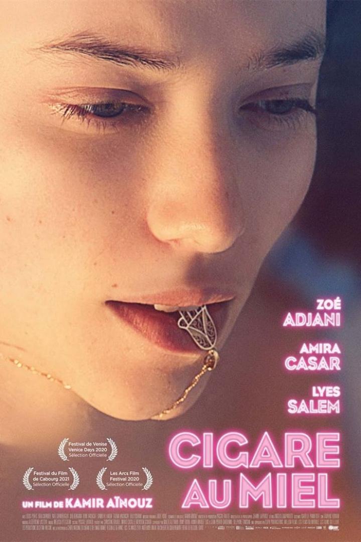 Das Filmplakat für „Cigare au Miel“ zeigt das Gesicht einer jungen Frau mit einem Schmuckstück im Mund.