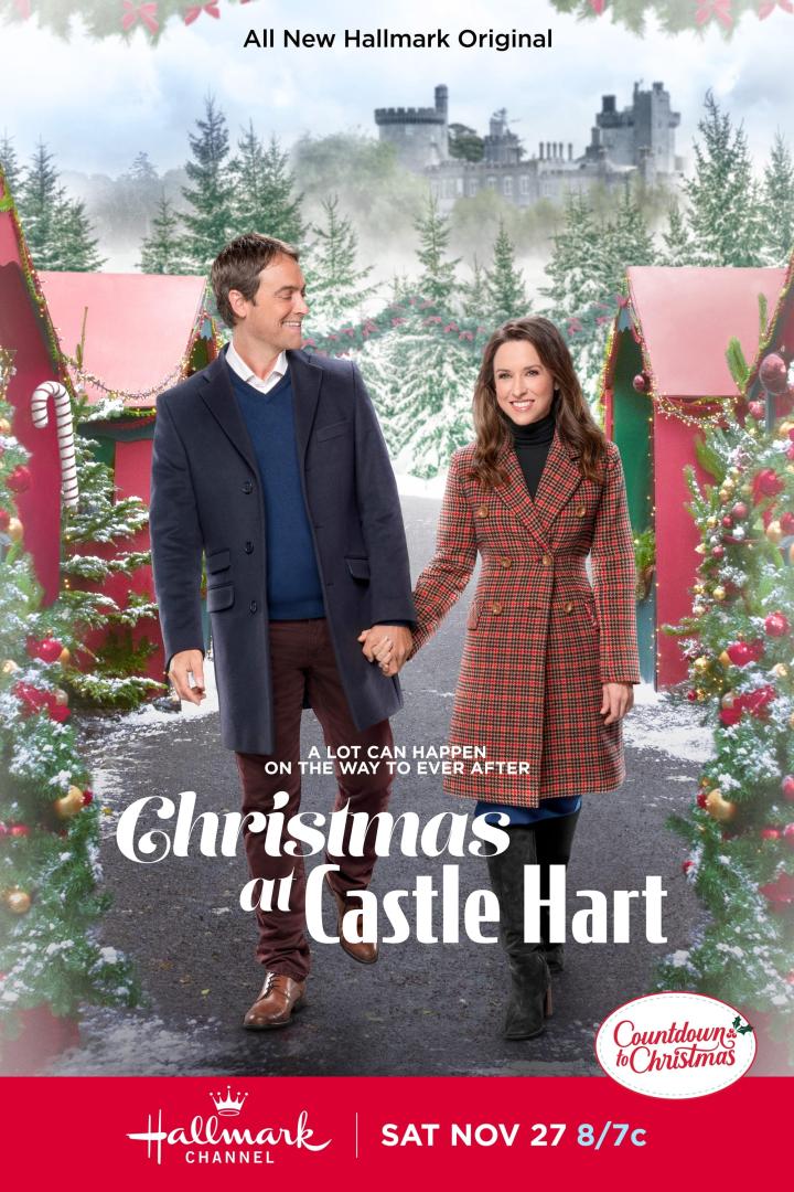 Ein Paar hält Händchen vor einem Schloss, dekoriert für „Christmas at Castle Hart“.