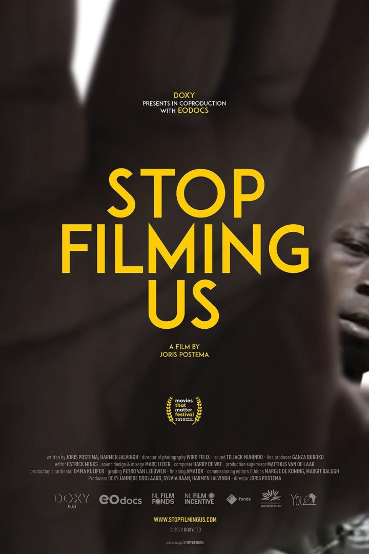 Das Filmplakat für „Stop Filming Us“ zeigt den Titel in gelber Schrift vor einem unscharfen Hintergrund.
