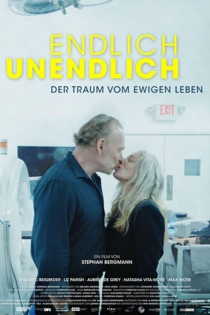 Ein Mann und eine Frau küssen sich vor dem Hintergrund des Filmplakats „Endlich unendlich“.